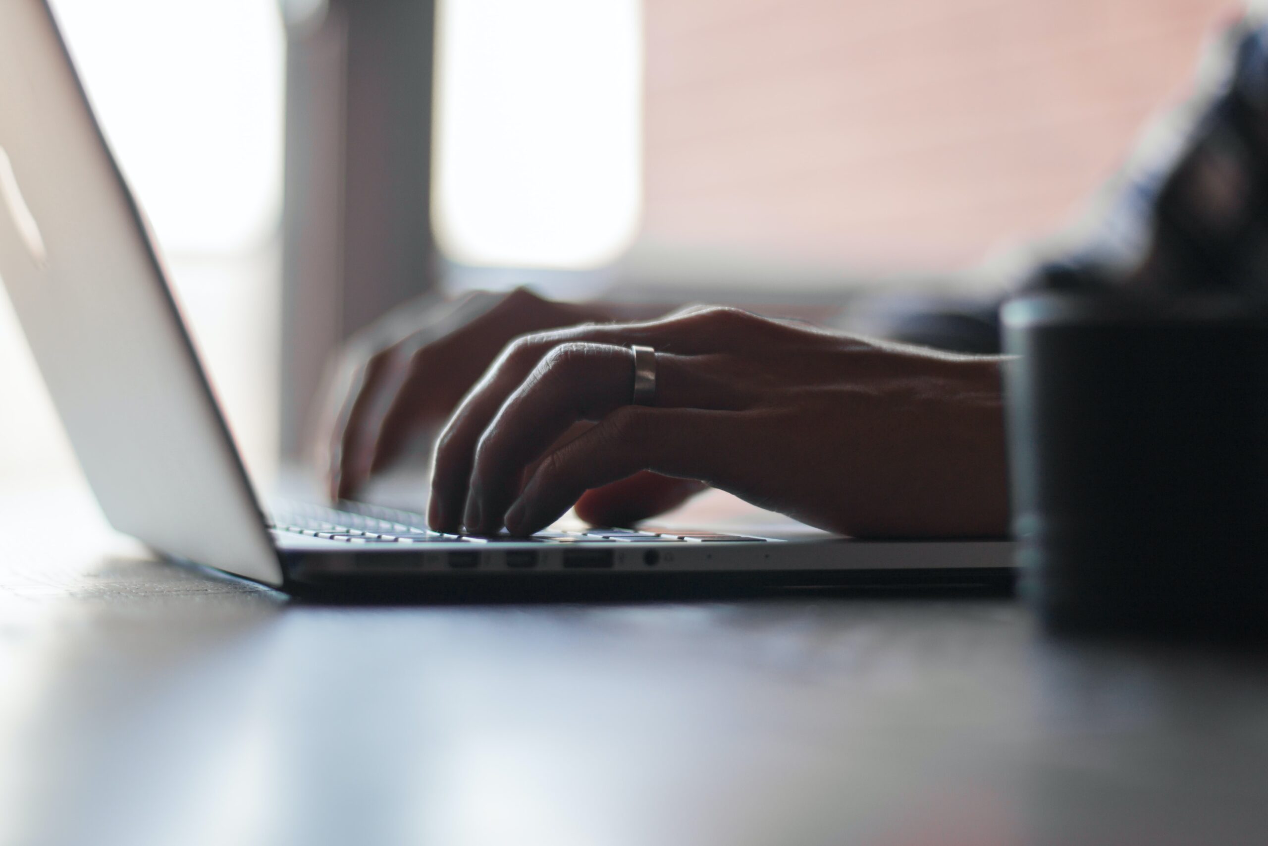 two hands typing in a laptop